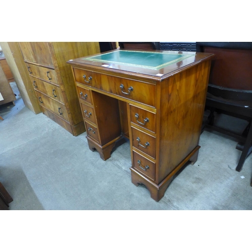 102 - A small yew wood and green leather topped kneehole desk