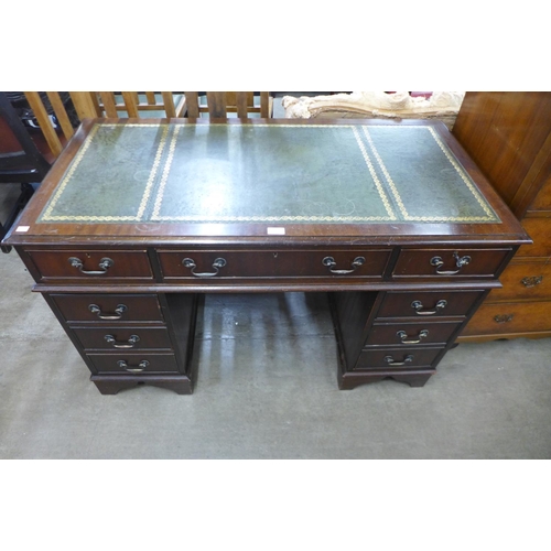 104 - A mahogany and green leather topped pedestal desk