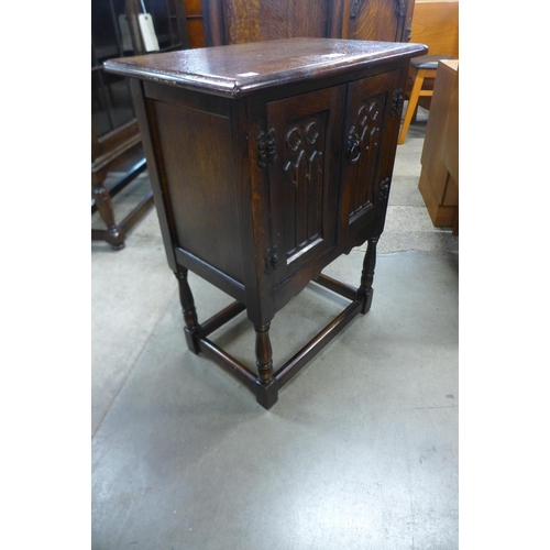 109 - A small carved oak two door cupboard