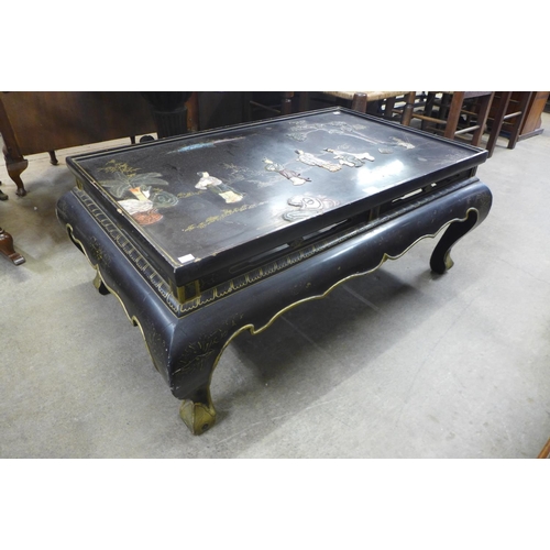 137 - An oriental chinoiserie ebonised coffee table (lacking glass )