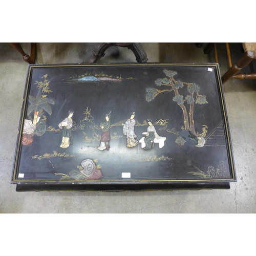 137 - An oriental chinoiserie ebonised coffee table (lacking glass )