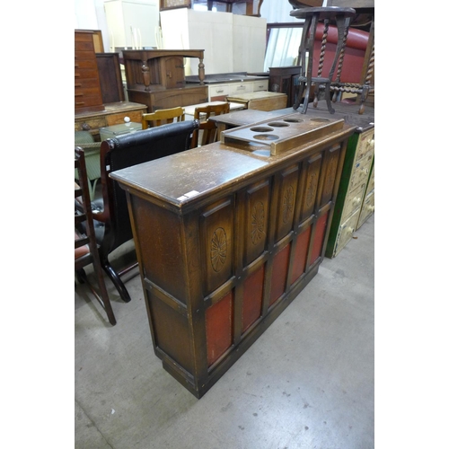 170 - A carved oak and red leather panelled corner bar