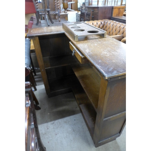 170 - A carved oak and red leather panelled corner bar