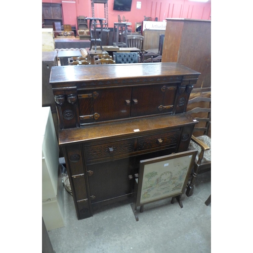 227 - A carved oak court cupboard and an embroidered firescreen