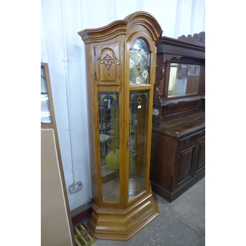 229 - A German carved oak triple weight longcase clock, with brass moonphase rolling dial