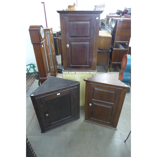 235 - A pair of walnut hanging corner cupboards and a George III oak hanging corner cupboard