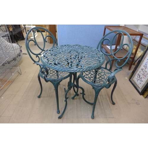 283 - A green cast alloy garden table and two chairs