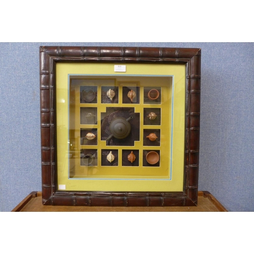 313 - A framed collection of Chinese miniature porcelain teapots and tea bowls