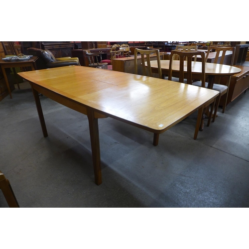 87 - A teak double leaf extending dining table