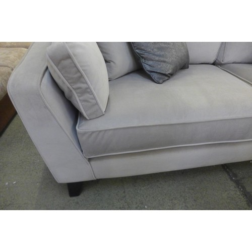 1697 - A taupe velvet four seater sofa