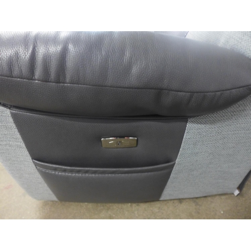 1535 - A black and grey upholstered electric reclining three seater sofa - damage, tear on the back of the ... 