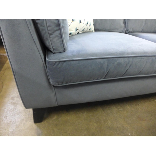1556 - A steel blue velvet three seater sofa
