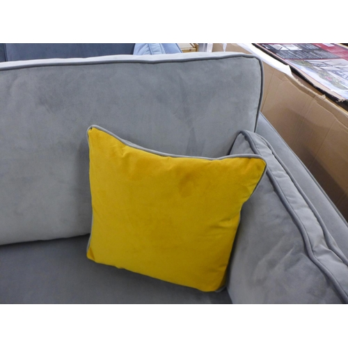 1557 - A grey velvet three seater sofa