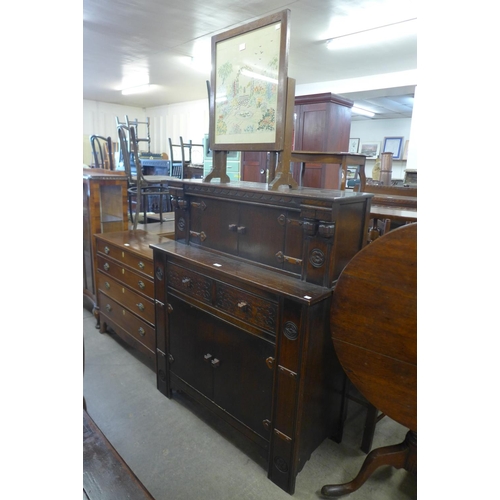 164 - A carved oak court cupboard and an embroidered firescreen