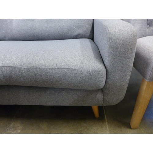 1422 - A grey upholstered three seater sofa (damaged springs)