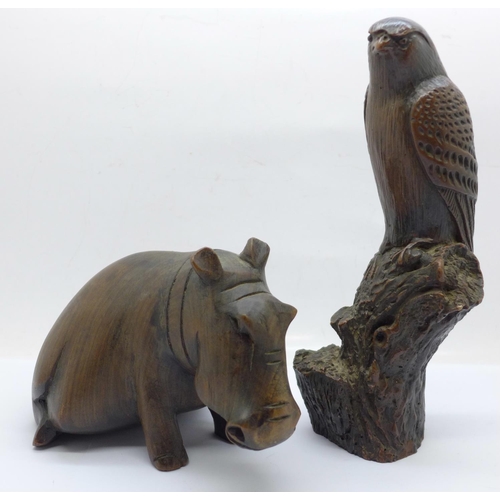 664 - A carved wooden hippopotamus and a resin hawk