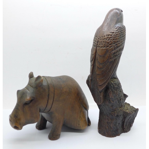 664 - A carved wooden hippopotamus and a resin hawk