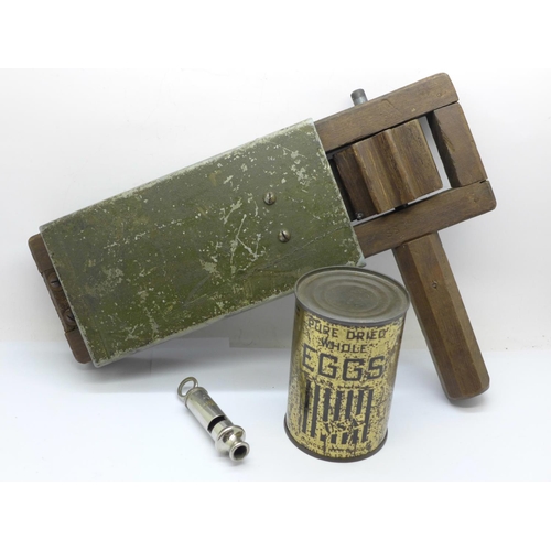 696 - A WWII rattle, ARP whistle and a tin of dried eggs