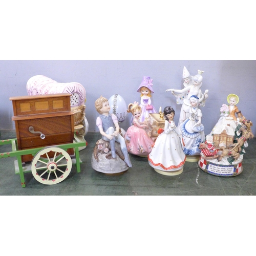 805 - Nine musical figurines, a pottery wagon and wooden cart