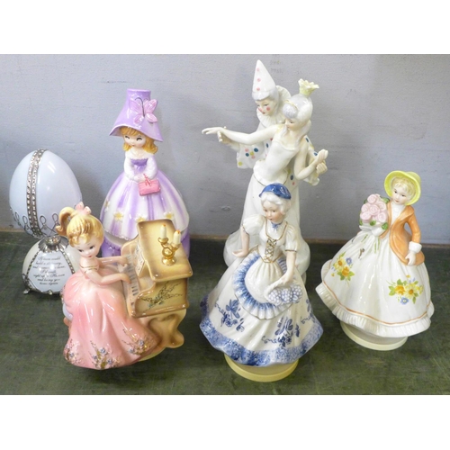 805 - Nine musical figurines, a pottery wagon and wooden cart