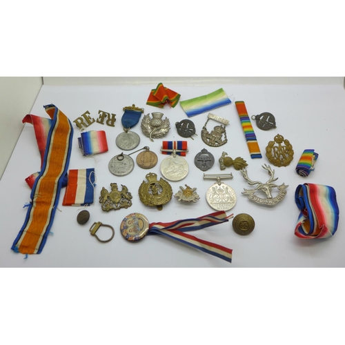 880 - A collection of military badges, medallions, medal ribbons, etc.