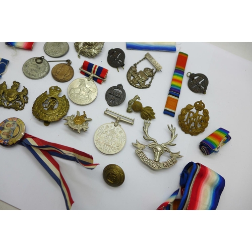 880 - A collection of military badges, medallions, medal ribbons, etc.