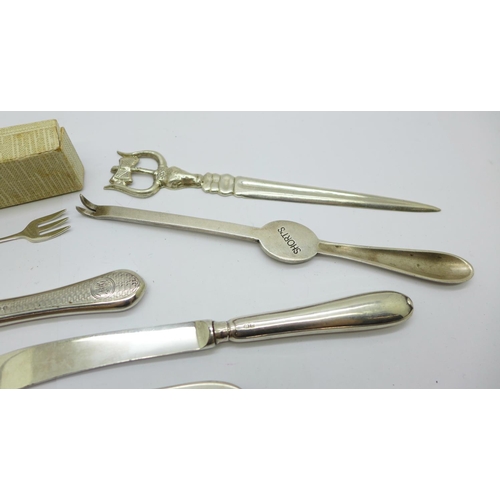 923 - A silver handled magnifying glass, two silver forks, a silver butter spreader, a letter opener, etc.