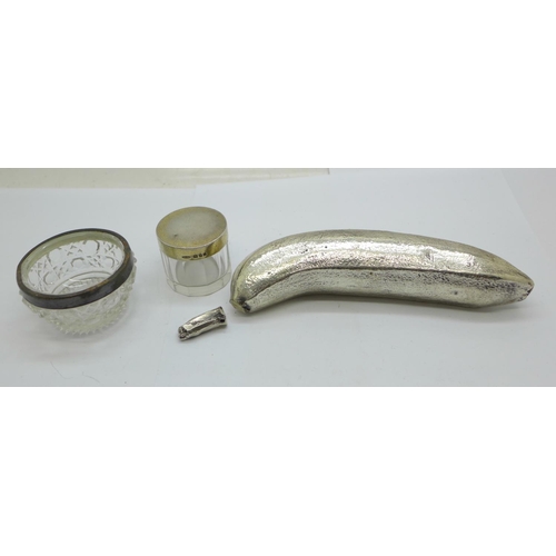 930 - A silver banana (silver covered, marked 'Filled'), a/f, a silver rimmed salt and a silver topped gla... 