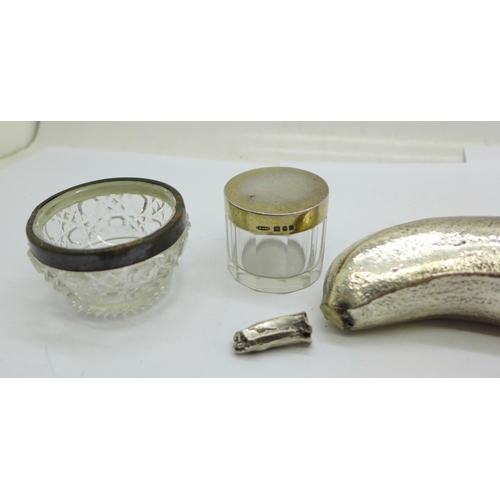 930 - A silver banana (silver covered, marked 'Filled'), a/f, a silver rimmed salt and a silver topped gla... 