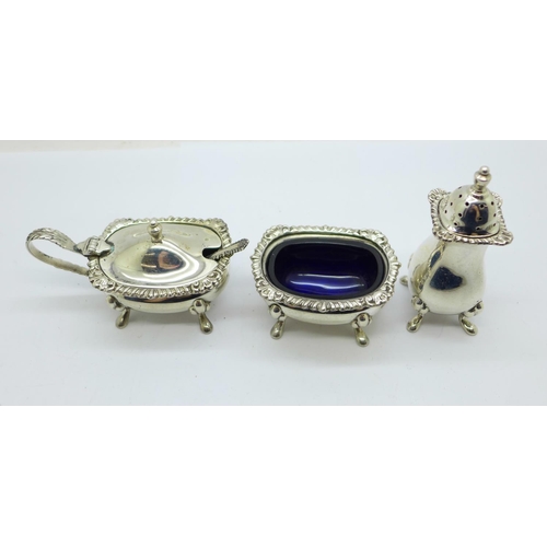 931 - A three piece silver cruet set with blue glass liners, 126g of silver