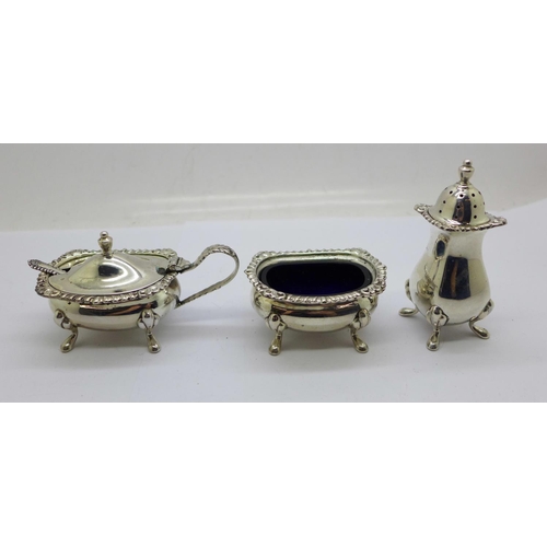 931 - A three piece silver cruet set with blue glass liners, 126g of silver