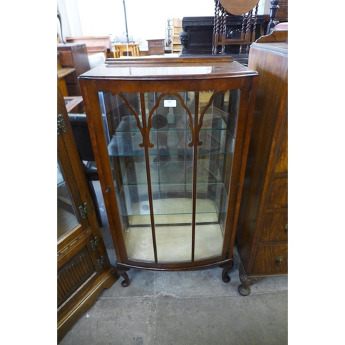 100 - A walnut single door bow front display cabinet