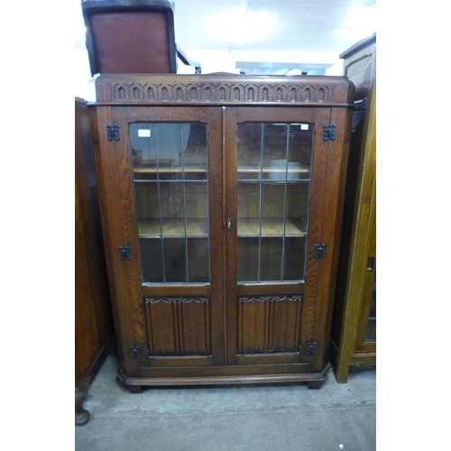 103 - A carved oak linenfold two door bookcase