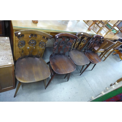 134 - A set of four Ercol dark elm and beech fleur de lys chairs