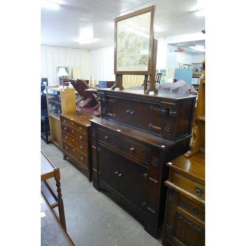 164 - A carved oak court cupboard and an embroidered firescreen