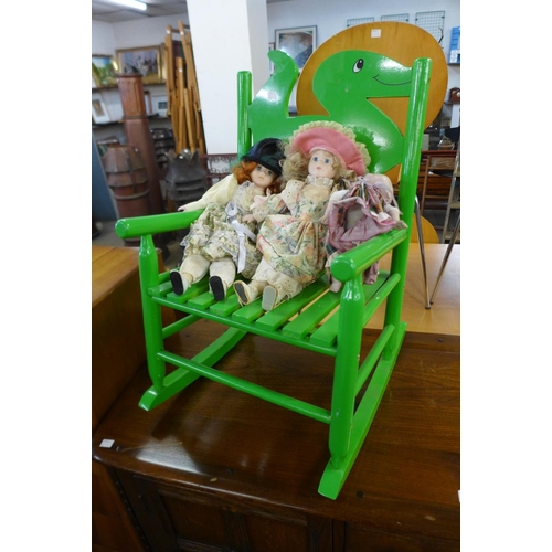 212 - A painted child's rocking chair and three dolls