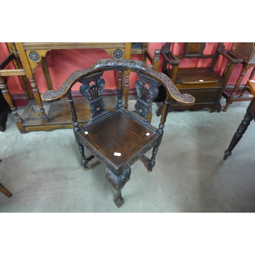 23e - A 17th Century style carved oak corner elbow chair