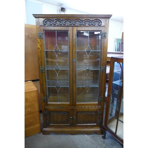 99 - An Old Charm carved oak linenfold four door cabinet