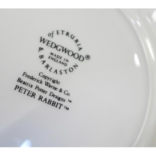 689 - A collection of Wedgwood Peter Rabbit children's mugs and plates and a boxed set of nursery tea ware... 