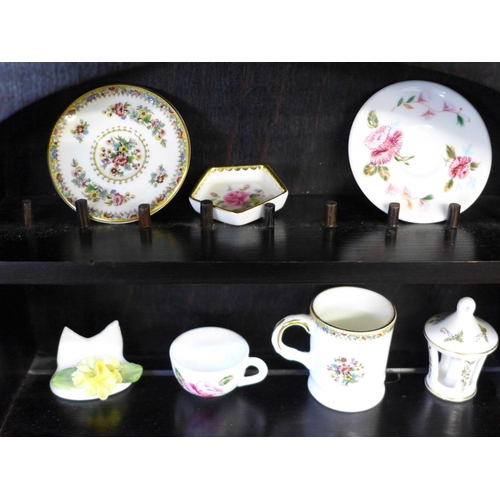 694 - A miniature Coalport tea set and ornaments, on display shelves
