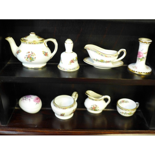694 - A miniature Coalport tea set and ornaments, on display shelves