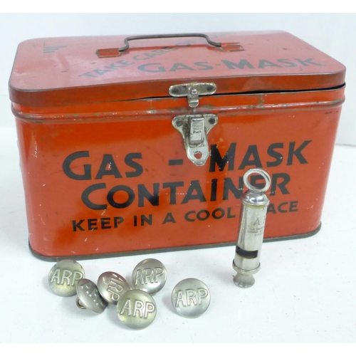 736 - A WWII ARP gas mask tin, an ARP whistle and six ARP buttons