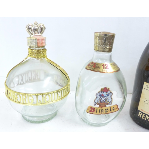 821 - A bottle of Grand Marnier and a bottle of Remy Martin, and two empty bottles