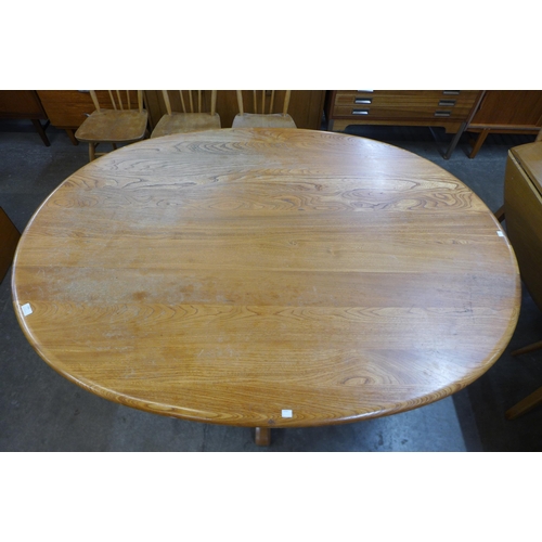 105 - An Ercol elm and beech pedestal dining table