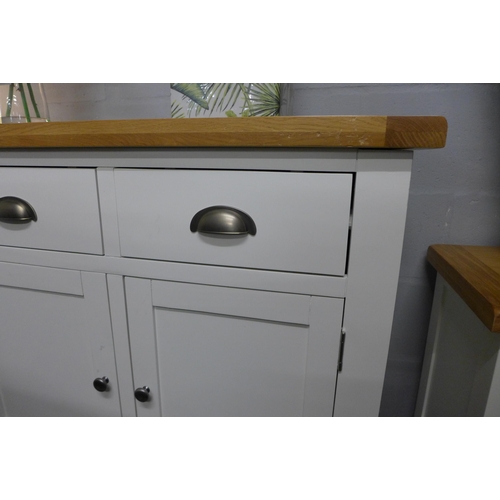 1336 - A Chester white painted oak two door small sideboard damaged to right hand side,missing foot pad to ... 