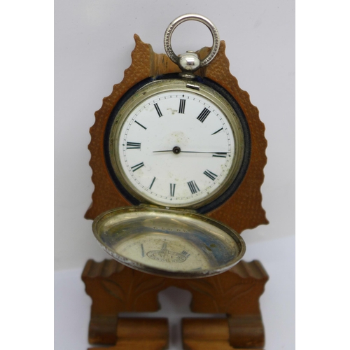 1114a - A silver fob watch and a carved wooden watch box/stand, a/f