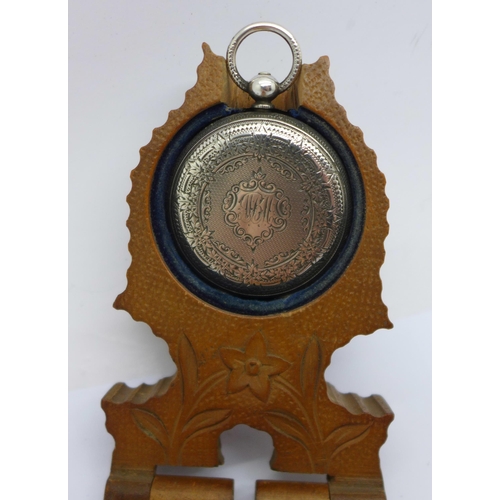 1114a - A silver fob watch and a carved wooden watch box/stand, a/f