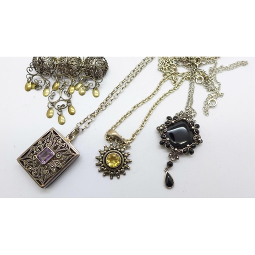 1125 - Three silver pendants and chains and a silver brooch