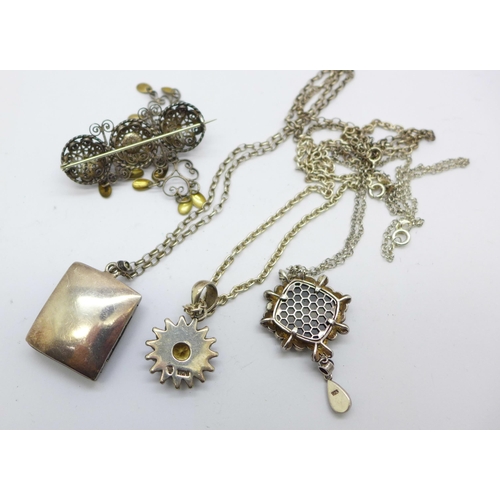 1125 - Three silver pendants and chains and a silver brooch