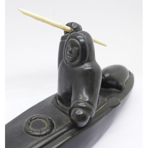 638 - A carved soapstone model of an Inuit in a canoe, 26.5cm